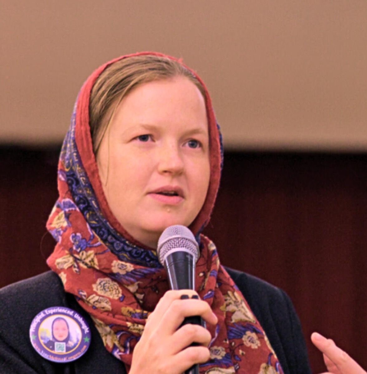 Melissa Chaudhry speaking into a microphone at a public event.